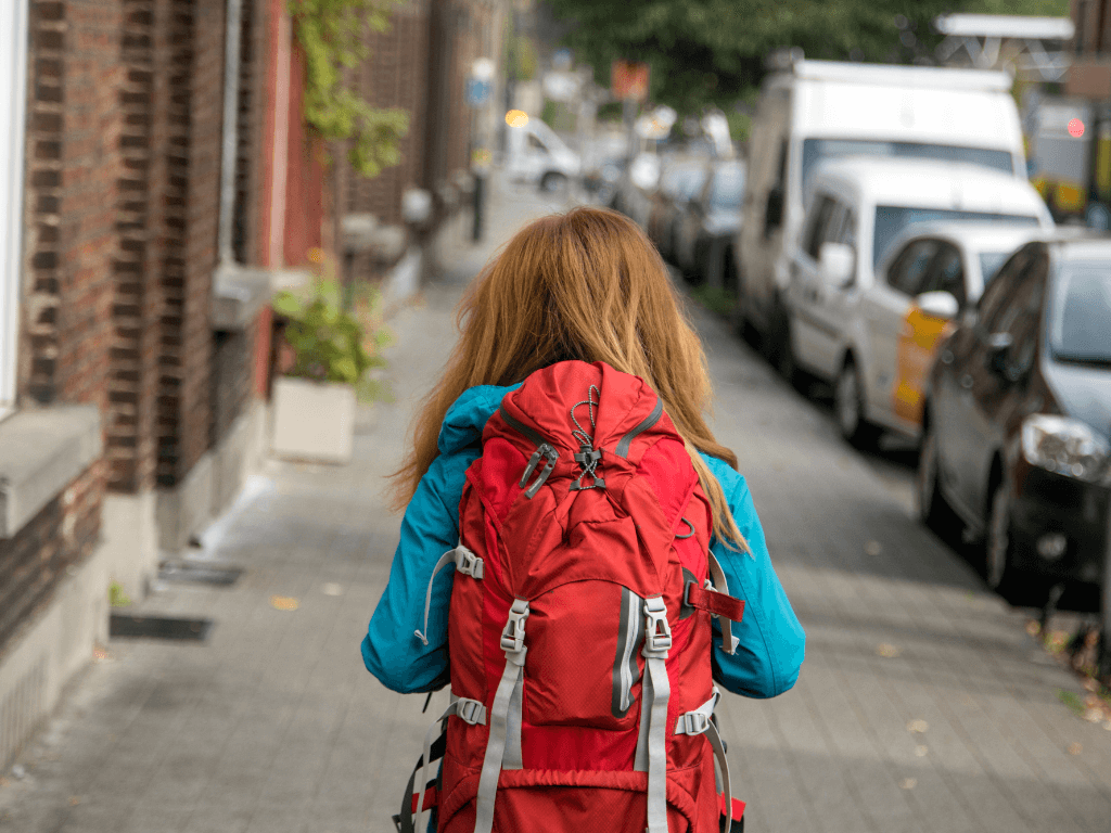 Female Traveler Walking to Hostel with Backpack
