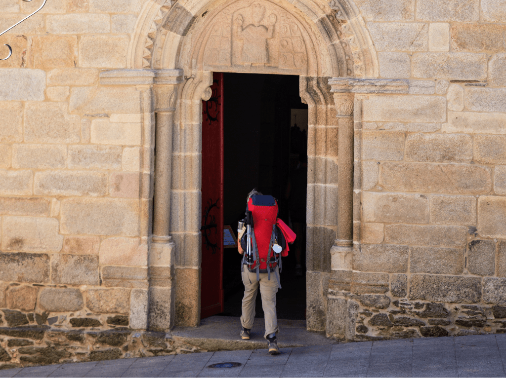Pilgrim entering Iglesia San Salvador in Sarria, Spain