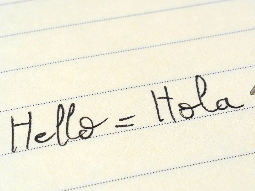 paper with hello = hola written on it
