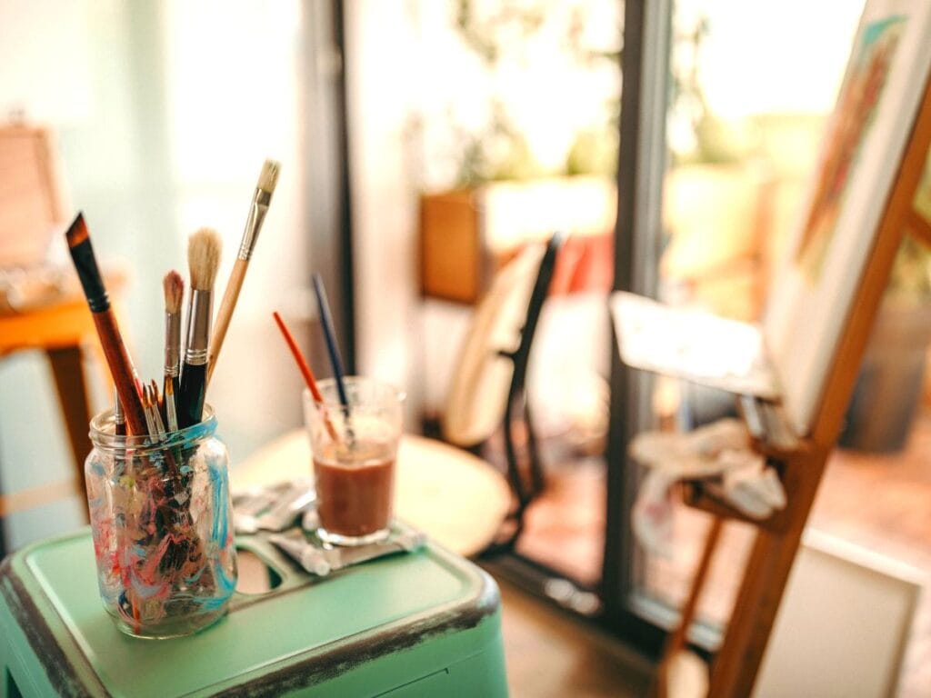 artist studio with easel paint and water to clean paintbrushes