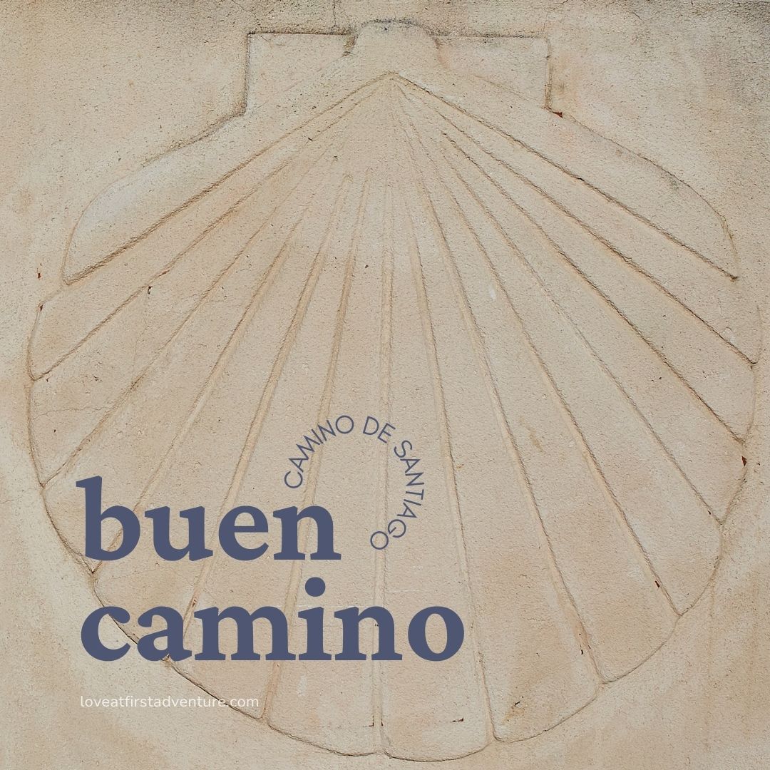 stone shell on the facade of a building with the words Buen Camino Camino de Santiago overlayed on top